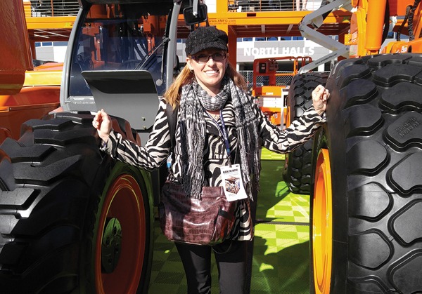Karen Hickey, editor of Masonry, poses between two Xtreme telehandlers.
