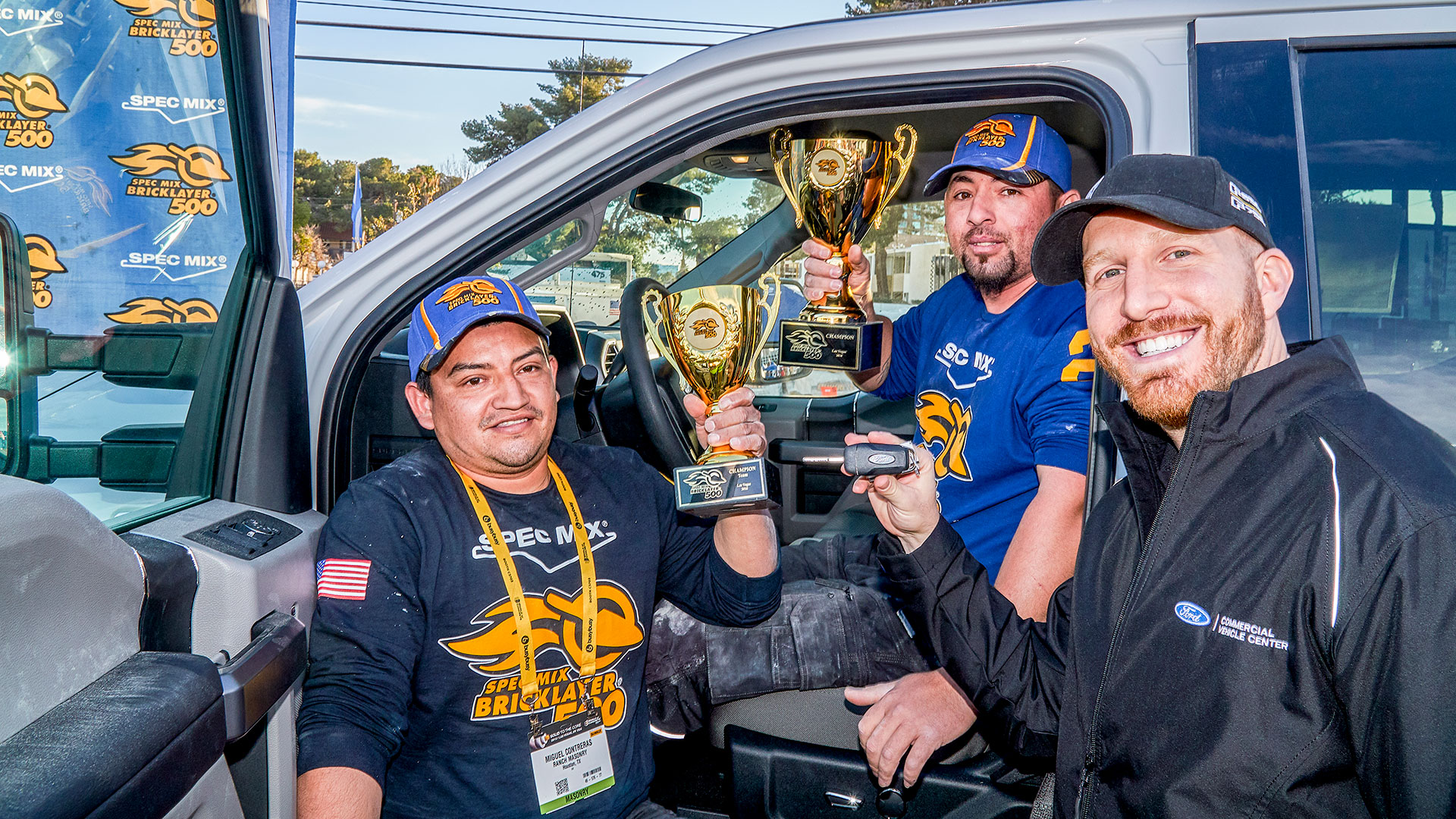 Cory Belonzi (right) with Ford Commercial Vehicles hands over the keys to a 2018 Ford F-250 Super Duty Truck to World Champion David Chavez (middle) as he holds up the SPEC MIX BRICKLAYER 500&reg; World Championship ceremonial trophy.