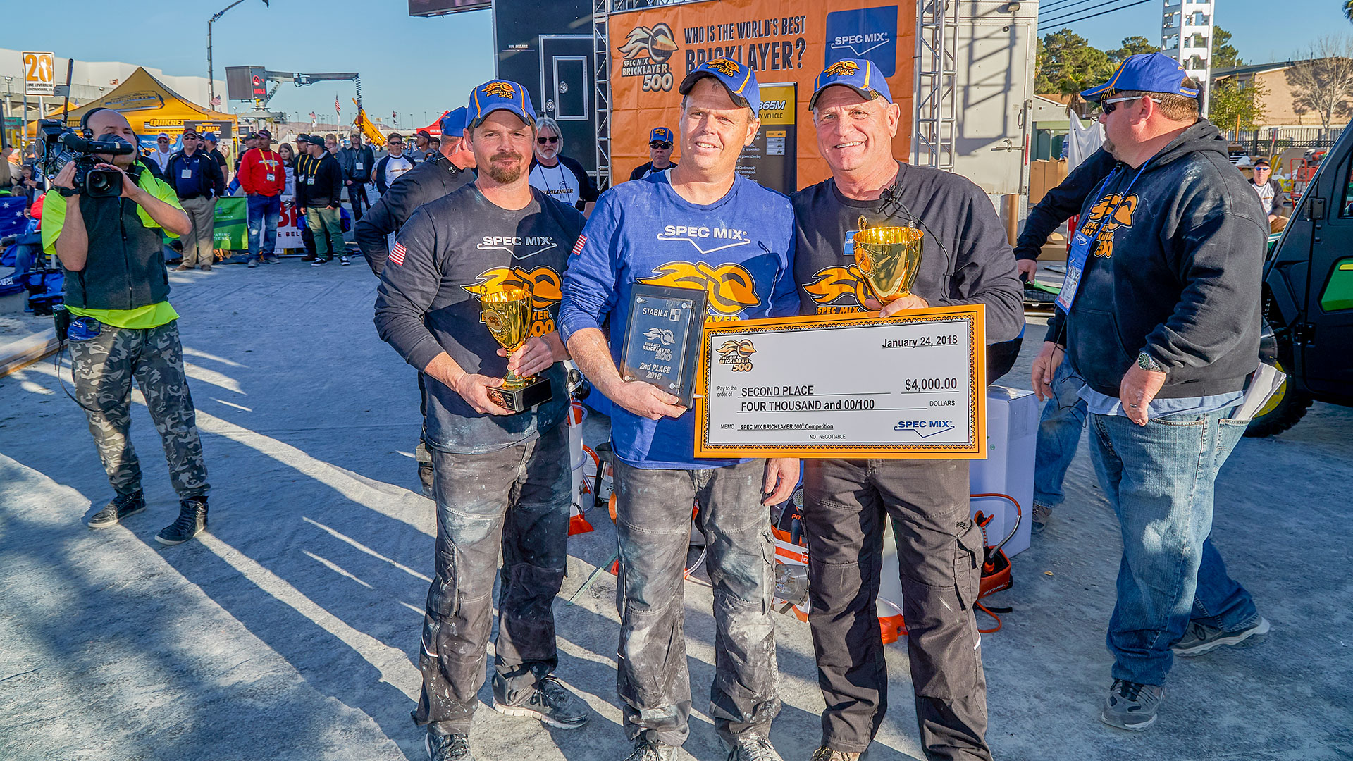 Brian Tuttle (middle) won second place with 689 brick laid. David’s mason tender and brother, Scott Tuttle (left) a former Spec Mix Bricklayer 500&reg; World Champion.