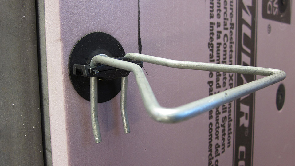 Thermally efficient single barrel veneer anchor including thermal break technology and air barrier sealing washer.
